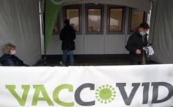 People arrive at a vaccination center to receive a dose of Oxford/AstraZeneca's COVID-19 vaccine in Antwerp, Belgium, March 18, 2021.