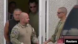 Cesar Sayoc (berkaos hitam), saat keluar dari fasilitas FBI di Miramar, Florida, (26/10). (Foto: WPLG/Local10.com/via REUTERS)
