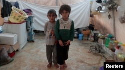 Des frères et sœurs syriens, déplacés de l'est de la province d'Idlib, posent pour une photo dans une tente du camp d'Atmeh en Syrie, près de la frontière turque, le 19 juin 2020.