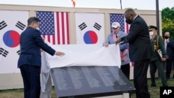 한국의 문재인 대통령이 지난 달 미한 정상회담 공동 기자회견 뒤 한국전 참전용사 기념공원에서 열린 추모의 벽 착공식에 참석해 로이드 오스틴 미 국방장관과 함께 명판을 가리고 있던 현수막을 걷어 냈다. 