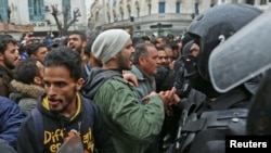 Des manifestants tunisiens s'affrontent avec la police anti-émeute lors de manifestations contre la hausse des prix et les augmentations d'impôts, à Tunis, en Tunisie, le 12 janvier 2018.
