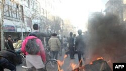 Iranian anti-government protesters set a garbage can on fire, in Tehran, Iran, February 14, 2011