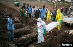 FILE - Health workers carry the body of an Ebola victim for burial at a cemetery in Freetown, Dec. 17, 2014.