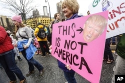 A woman holds a sign at the Women's March in Atlanta, Jan. 21, 2017. The rally and march drew thousands of attendees, including U.S. Rep. John Lewis, who had been at odds with President Donald Trump leading up to the inauguration.