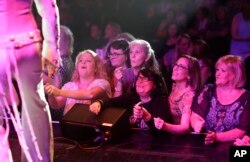 Fans stand in front of the stage after a concert by professional Elvis tribute artists during the "Images of the King: Las Vegas" festival in Las Vegas, July 15, 2017. "In my opinion they want to see an illusion of the man and his music," said festival producer Terri Futreal.