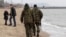File - Local volunteers patrol the city beach in Mariupol, Donetsk region of Ukraine.