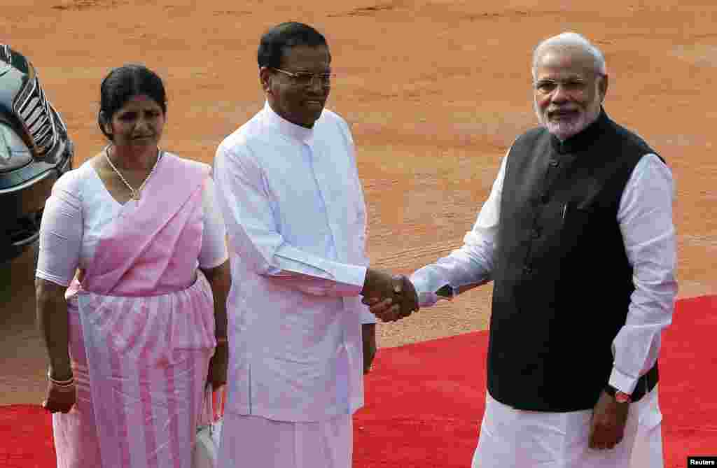 Sri Lanka&#39;s President Mithripala Sirisena (center) shakes hands with Indian Prime Minister Narendra Modi as his wife Jayanthi Sirisena looks on during the reception of Sirisena at the Rashtrapati Bhavan Presidential Palace in New Dehli, Feb. 16, 2015.