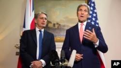 Menteri Luar Negeri AS John Kerry, kanan, menjawab pertanyaan tentang krisis berkepanjangan di Suriah dalam sebuah konferensi pers dengan Menteri Luar Negeri Inggris Philip Hammond, 19 September 2015, di London. 