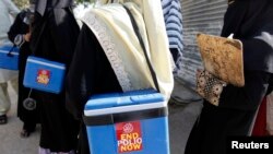 Tim vaksinasi polio membawa kotak-kotak vaksin polio menuju wilayah tempat mereka ditugaskan untuk memberikan vaksin, di Karachi, 21 Oktober 2014. (Foto: dok.)
