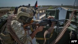 FILE - A security personnel stands guard on top of a vehicle outside United Nations Assistance Mission in Afghanistan (UNAMA) office compound in Guzara district of Herat province, July 31, 2021.