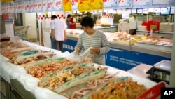 Seorang pelanggan membeli ayam di sebuah supermarket di Beijing, 12 Mei 2017. 