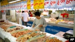 A woman shops for chicken at a supermarket in Beijing, May 12, 2017. China will finally open its borders to U.S. beef while cooked Chinese poultry is closer to hitting the American market as part of a U.S.-China trade agreement. 