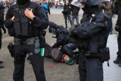 FILE - A protester from the initiative Querdenken, which opposes coronavirus restrictions, is detained by police during a demonstration in Frankfurt am Main, western Germany, Nov. 14, 2020.