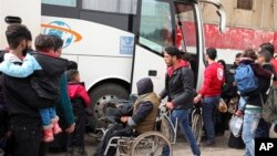 Anggota Palang Merah Suriah membantu keberangkatan para pejuang oposisi dan keluarga mereka saat mereka bersiap untuk meninggalkan lingkungan al-Waer, menuju sebuah kota di perbatasan Turki, di Homs, Suriah, Sabtu, 18 Maret 2017.(Foto: dok).