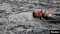 People take a mud bath during the "Iron mud" festival in the town of Zheleznovodsk, in Stavropol region, Russia, August 24, 2019. (REUTERS/Eduard Korniyenko)