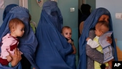 FILE - Women hold babies suffering from malnutrition as they wait at a UNICEF clinic in Jabal Saraj, north of Kabul, Afghanistan, Aug. 26, 2019. The UNICEF representative in the country says his agency and its female staff are continuing to work there despite Taliban restrictions