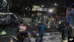 Police and security officers cordon off the area of a deadly bombing, in Lahore, Pakistan, Feb. 13, 2017.