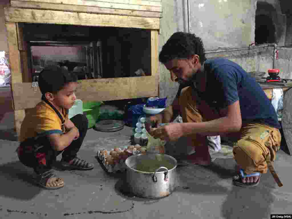 Yemeni refugee Wasiim Said Mohamed and his son at the bakery where Mohamed works for his Syrian friend, in Hargeisa, Somaliland, March 31, 2016.