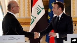 French president Emmanuel Macron, right, shakes hands with Iraqi President Barham Saleh after a press conference at the Elysee Palace in Paris, Feb. 25, 2019.