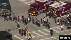 Para siswa dievakuasi dari SMA Marjory Stoneman Douglas ketika penembakan terjadi di Parkland, Florida, 14 Februari 2018.