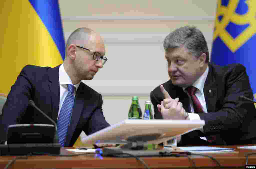 Ukrainian President Petro Poroshenko, right, talks with Prime Minister Arseniy Yatsenyuk during a government meeting in Kyiv, Sept. 10, 2014.