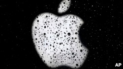 FILE-Apple's logo is seen in raindrops on a window outside an Apple Store in Kansas City, Mo.