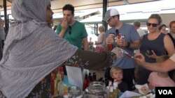 People buy hot sauce from Hibo Egeh. Her hot sauces are sometimes her native Somalian and sometimes her own invention. (J. Soh/VOA)