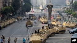 FILE - Egyptian army soldiers take their positions on top and next to their armored vehicles while guarding an entrance to Tahrir square, in Cairo, Egypt, Friday, Aug. 16, 2013. 