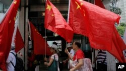 FILE - China supporters march with Chinese national flags during a rally to mark the 18th anniversary of Hong Kong's handover to China, in Hong Kong, July 1, 2015.