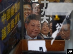 FILE - A book featuring a photo of Chinese President Xi Jinping and other officials on the cover, is showed at the entrance of the closed Causeway Bay Bookstore in Hong Kong, Feb. 5, 2016.