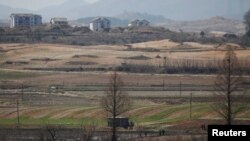 FILE - North Korean people work in a rice field at the propaganda village of Gijungdong in North Korea, in this picture taken near the truce village of Panmunjom inside the demilitarized zone, April 11, 2018. 