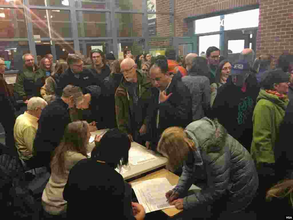 Caucus-goers register at Hanawalt Elementary School, Des Moines, Iowa, Feb. 1, 2016. (M. Cagler/VOA) 