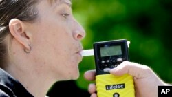 Petugas Patroli Jalan Raya California, Jaimi Kenyon memperagakan cara menggunakan 'breathalyzer' (perangkat yang digunakan untuk menguji pengemudi yang diduga mengalami gangguan saat mengemudikan kendaraan), di Sacramento, California, 10 Mei 2017. (Foto: dok).