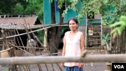 ប្រជាពលរដ្ឋម្នាក់​រស់​នៅ​ក្នុង​ភូមិ​ប្រតោង អ្នកស្រី ធ្លក ពៅ អាយុ​៤៥ឆ្នាំ ដើរ​នៅ​ខាងមុខ​ផ្ទះ​របស់​អ្នកស្រី ក្នុង​ឃុំ​ស្វាយភ្លើង កាល​ពីថ្ងៃ​ទី​១៣ ខែកក្កដា ឆ្នាំ២០១៧។ (ស៊ុន ណារិន/VOA)