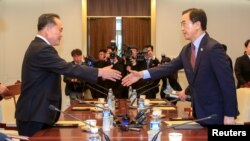 Menteri Unifikasi Korea Selatan, Cho Myoung-gyon berjabat tangan dengan mitra Korea Utara, Ri Son Gwon dalam pertemuan di desa gencatan senjata Panmunjom, Korea Selatan, 1 Juni 2018.