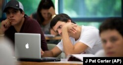 A University of Miami student studies the daily lesson plan on his computer during a Spanish language class in Coral Gables, Florida.