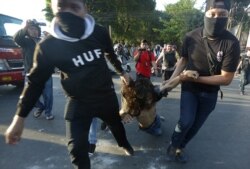 Plainclothes police officers arrest a student protester during a rally in Makassar, South Sulawesi province, Indonesia, Sept. 26, 2019. Students rallied across the country against a new law that critics say cripples the anti-corruption agency.