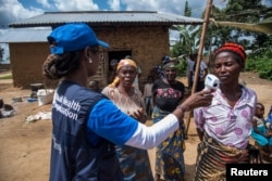 FILE - Marie-Roseline Darnycka Belizaire, World Health Organization (WHO) Epidemiology Team Lead, talks to women as part of Ebola contact tracing, in Mangina, Democratic Republic of Congo, Aug. 26, 2018.