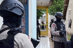 Petugas polisi berjaga di luar rumah tersangka militan setelah polisi antiteror dari unit Densus 88 di Serpong, Tangerang Selatan, 21 Desember 2016. (Foto: Antara/Fakhri Hermansyah via REUTERS)