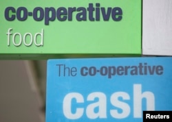 Signs are displayed outside of a branch of a Co-operative food store in north London, April 17, 2014.