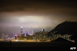 FILE - This general view taken late on February 25, 2018 shows ships sailing in the waters off Hong Kong and the city's skyline.