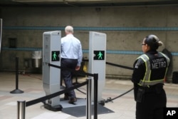 FILE - Chris McLaughlin, a vice president with Evolv Technology, test the company's body scanner at Union Station subway station in Los Angeles Wednesday, Aug. 16, 2017. (AP Photo/Mike Balsamo)