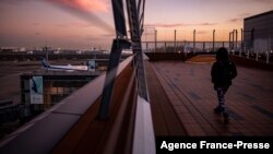 មនុស្ស​ម្នាក់ នៅ​រានហាល​ខាងក្រៅ​អាកាស​យានដ្ឋាន​អន្តរជាតិ Haneda ក្នុង​ទីក្រុង​តូក្យូ នៅ​ថ្ងៃទី២៩ ខែវិច្ឆិកា ឆ្នាំ២០២១ ខណៈ​ដែល​ប្រទេស​ជប៉ុន​បាន​ប្រកាស​ផែនការ​រារាំង​អ្នកដំណើរ​បរទេស​ថ្មី​ទាំងអស់​ដោយសារតែ​វីរុស​កូវីដ១៩ បំប្លែង​ថ្មី​អូមីក្រុង (Omicron)។