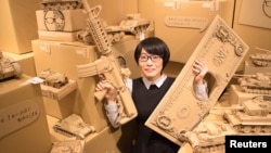 Artist Monami Ohno poses with several of her cardboard sculptures at a gallery event in Tokyo, Japan July 23, 2016. (Monami Ohno/Handout via REUTERS)
