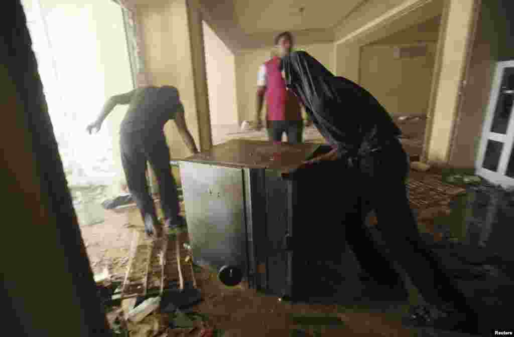 Penjarah di kantor pusat Muslim Brotherhood di distrik Muqattam di Kairo (1/7) setelah bangunan itu dibakar oleh para demonstran yang menentang Presiden Mohammed Morsi. (Reuters/Amr Abdallah Dalsh)