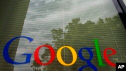 FILE - The Google logo on a window at the company's headquarters in Mountain View, Calif. 