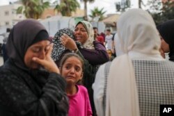 Para perempuan Palestina berduka di dekat jenazah kerabatnya yang tewas dalam serangan udara Israel, di luar kamar mayat Rumah Sakit Martir Al-Aqsa di Deir al Balah, Jalur Gaza, Senin, 10 Juni 2024. (Foto: AP)