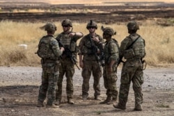 US soldiers stand at an oil field in the countryside of al-Qahtaniyah town in Syria's northeastern Hasakeh province near the Turkish border, on Aug. 4, 2020.