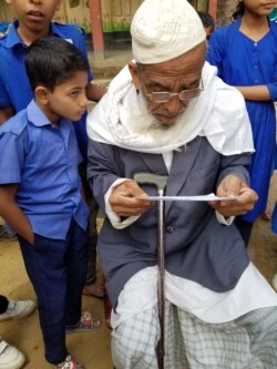 Abdul Hakim tries out new eyeglasses at a school in Rajapalong, in southeastern Bangladesh’s poor Cox’s Bazar district. (Carol Guensburg/VOA)
