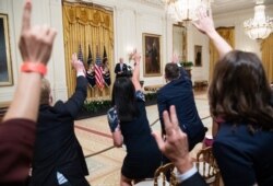 Reporters raise their hands as they shout questions to President Joe Biden after speaking about COVID-19 vaccinations in the East Room of the White House in Washington, July 29, 2021.